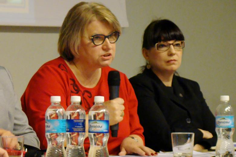 zdjęcie: dwie kobiety siedzą przy stole, jedna z nich mówi do mikrofonu