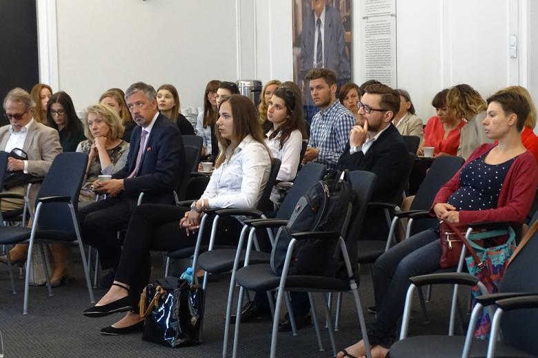 zdjęcie: kilkanaście osób siedzi na krzesłach na sali konferencyjnej