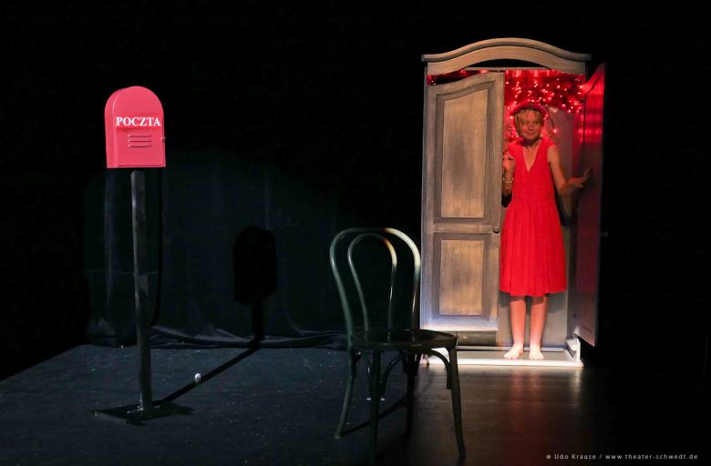 Aktorka teatru Bomba Bomba w czerwonej sukience stoi w szafie