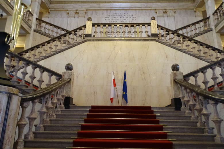 Reprezentacyjne schody z flagami: polską i unijną