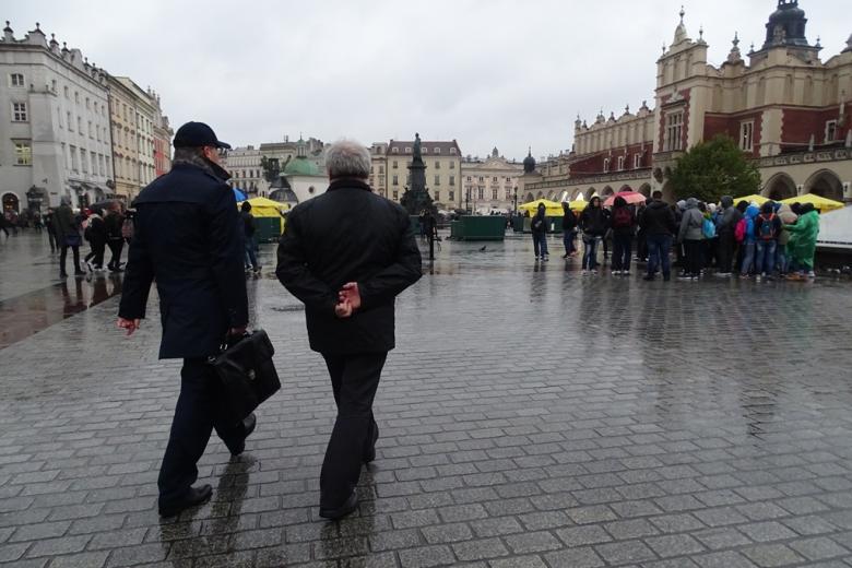 Zdjęcie: dwaj mężczyźni idą w stronę krakowskich Sukiennic