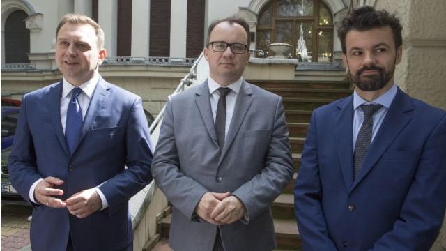 zdjęcie: na zdjęciu stoi trzech mężczyzn w garniturach