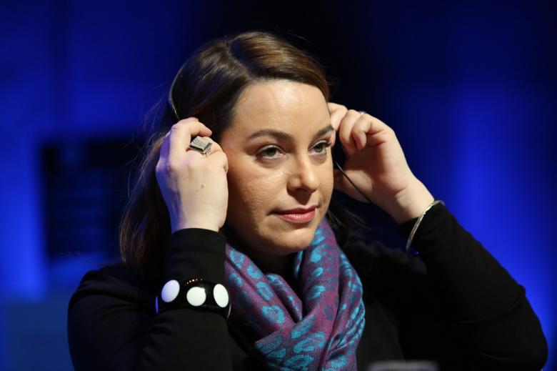 Kobieta zakłada słuchawki z tłumaczeniem debaty