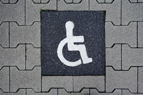 grafika z symbolem osoby z niepełnosprawnością na wózku