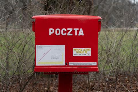 Czerwona skrzynka wrzutowa na listy z napisem "POCZTA"